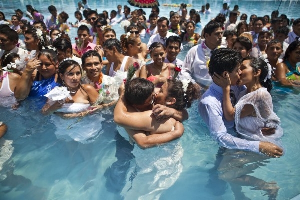 
	
	Hai cặp vợ chồng đang hôn nhau tại một hồ bơi công cộng trong lễ hội đám cưới tập thể dịp Valentine ở Lima. Hơn 200 cặp đã tham gia vào dịp đám cưới tập thể này, 14/02/2013